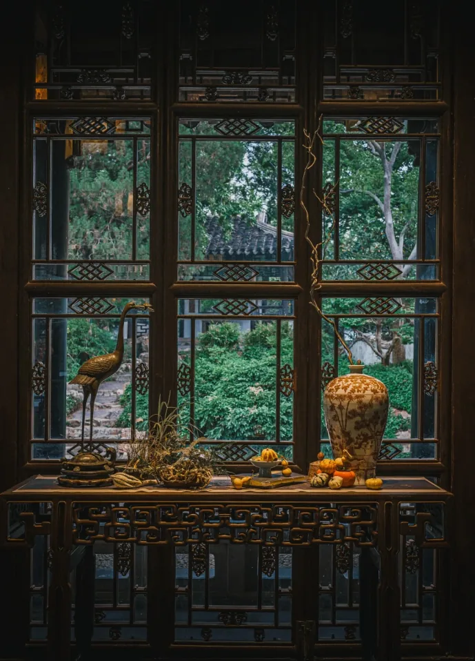 Carved window framing the garden from inside a hall