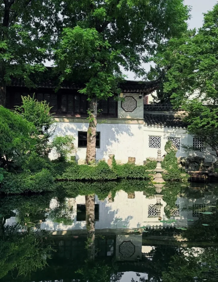 Lingering Garden: white walls and pavilions mirrored in still water
