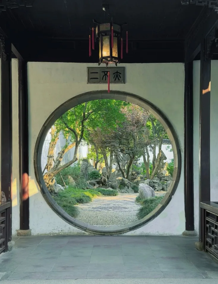 Lingering Garden: a moon gate framing the garden path beyond