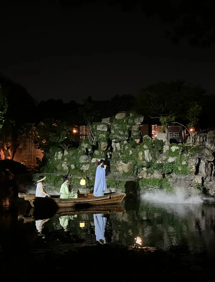 Master of the Nets Garden night show: performers in costume on a misty pond