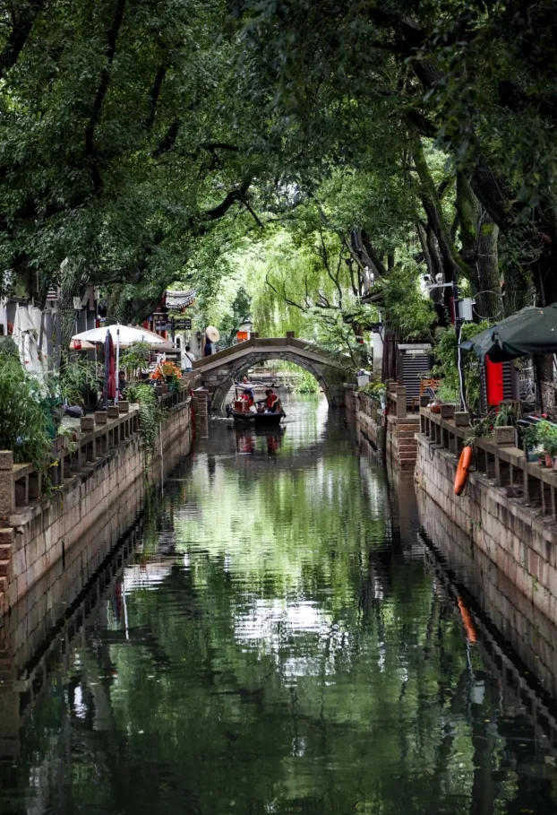 Tongli water town: a canal with an arched bridge between white-walled houses