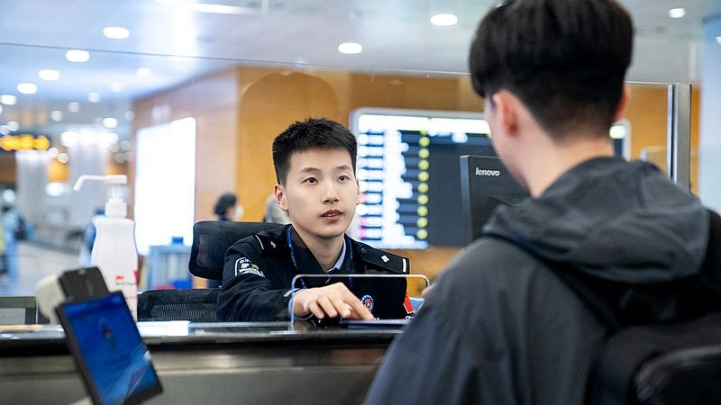 Immigration officer processing an arriving traveller at Shanghai Pudong airport